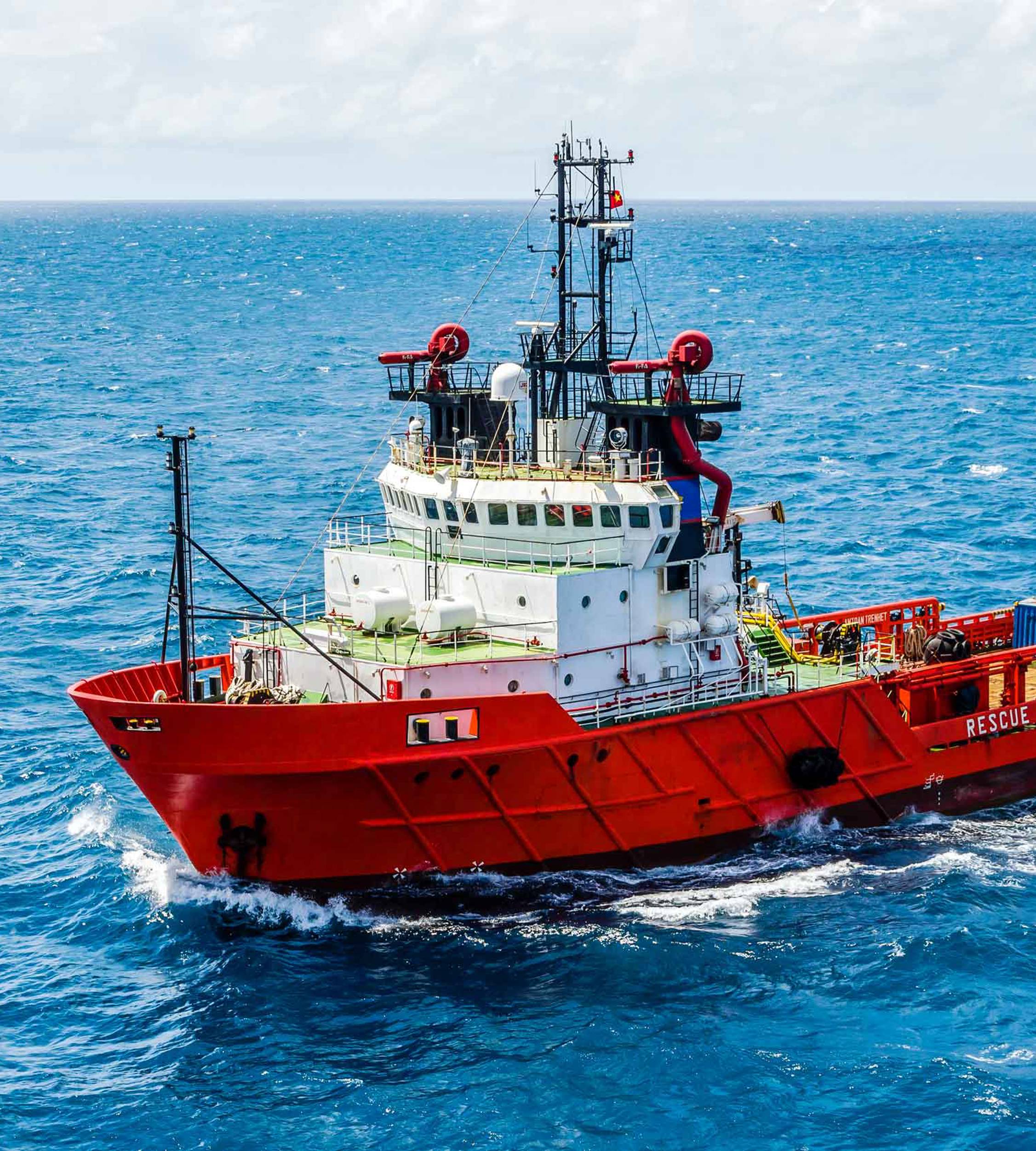 Supply boat at sea red hull