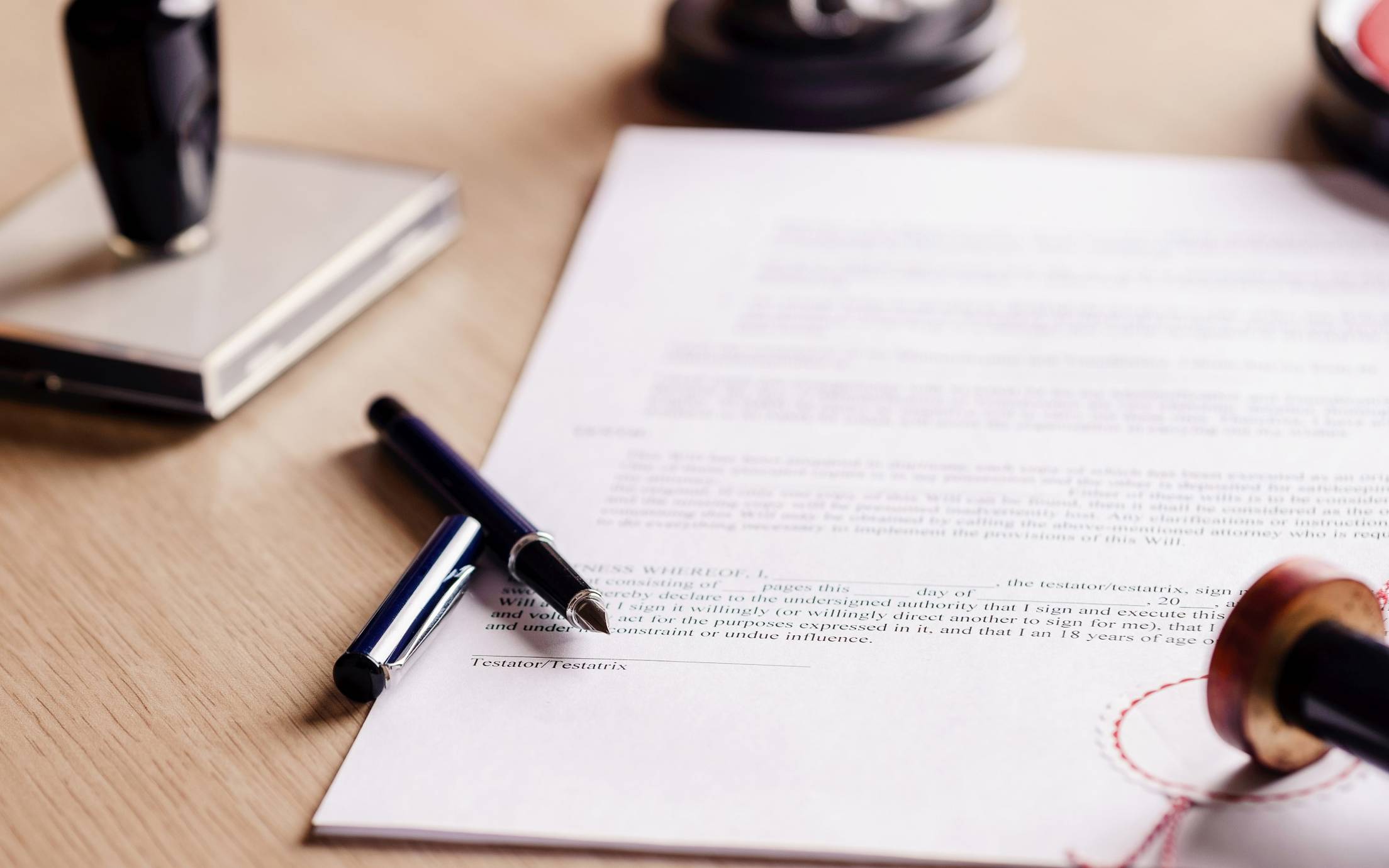 Photo of signed documents and pen laying next to it