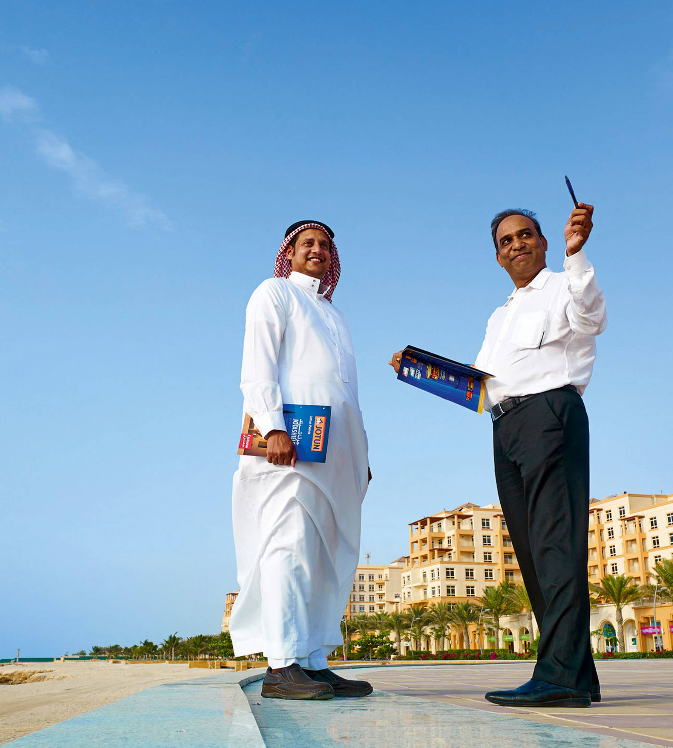 Two salesmen from the Middle East having a chat and smiling