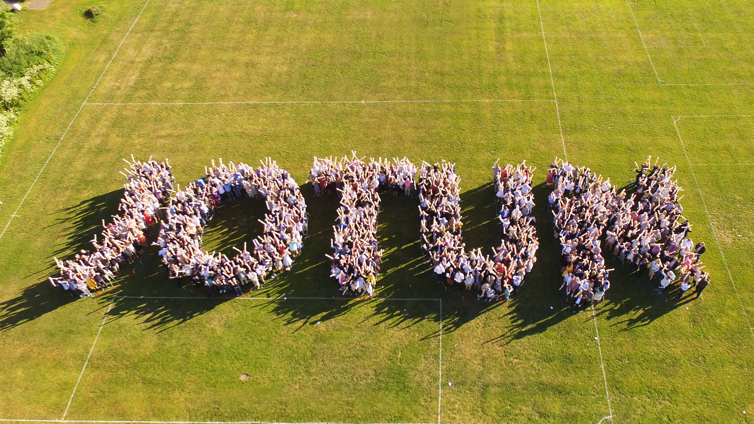 Many Jotun employees standing together outside in a formation that spell Jotun