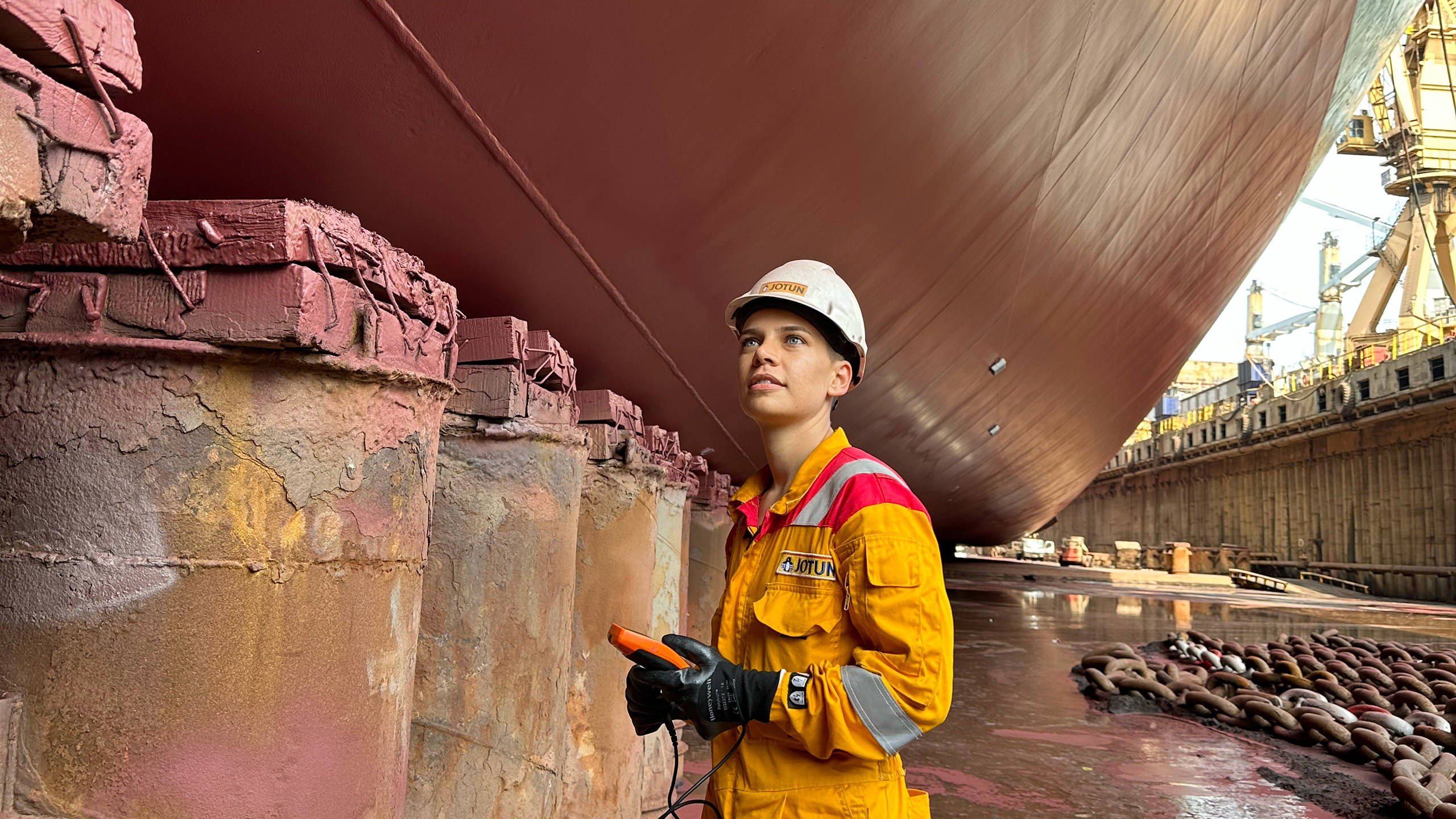 Nilay Yilmaz standing in the dock looking up on a ship hull