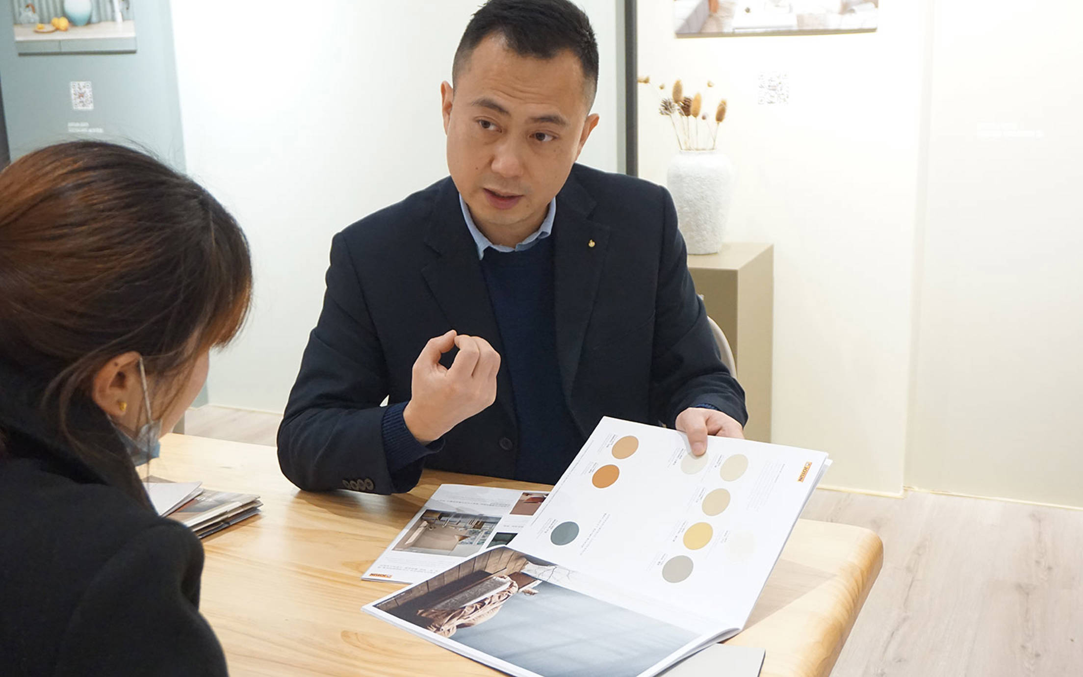 Two people in a Chinese Multicolor shop choosing colours from Jotuns new global colour card Together