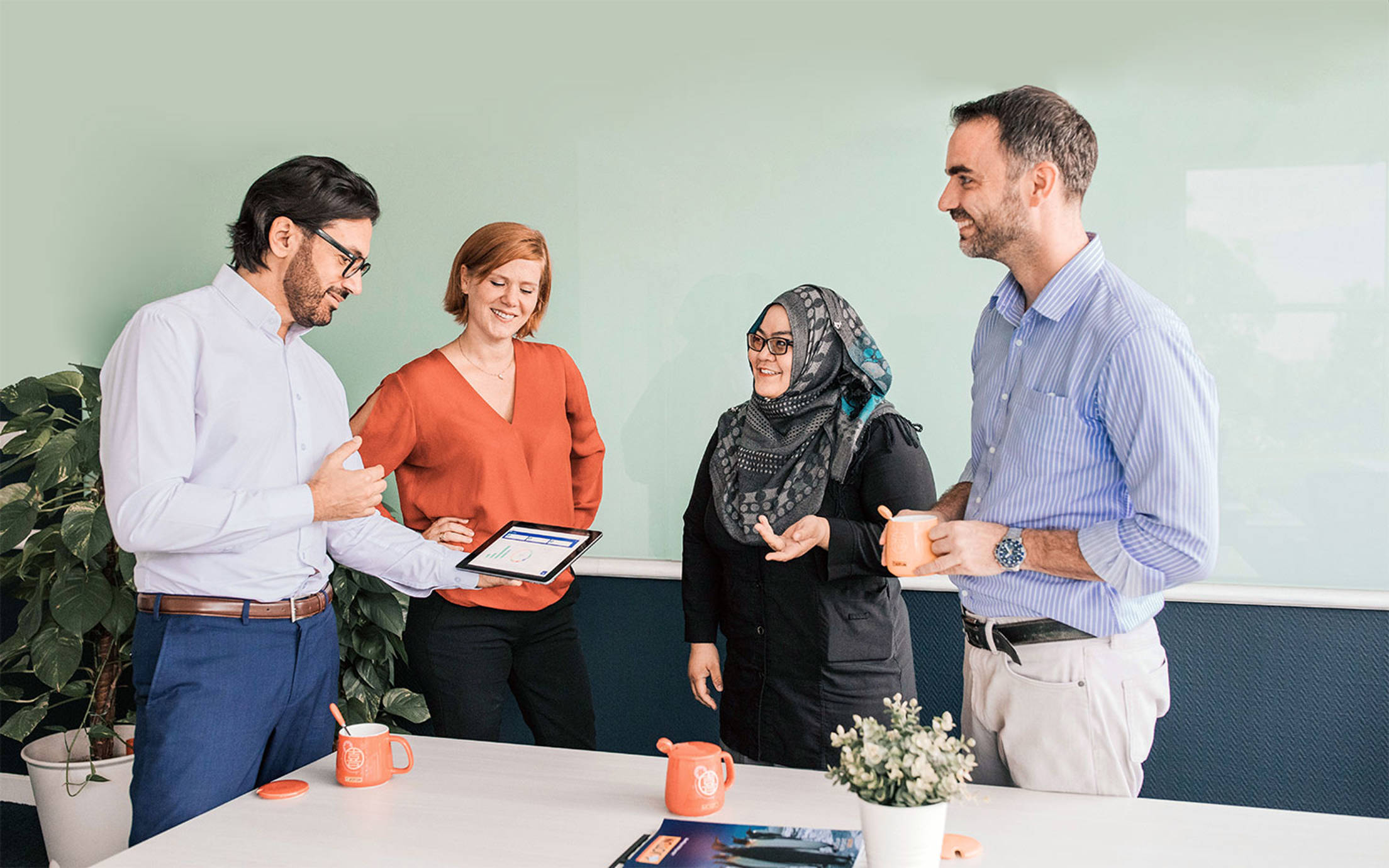 Four people standing in a meeting room